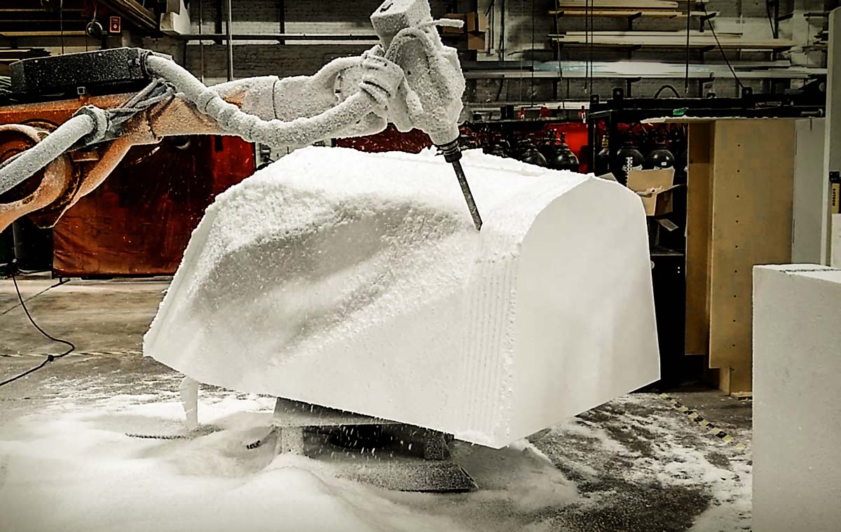 A piece of foam is carved by a type of CNC equipment