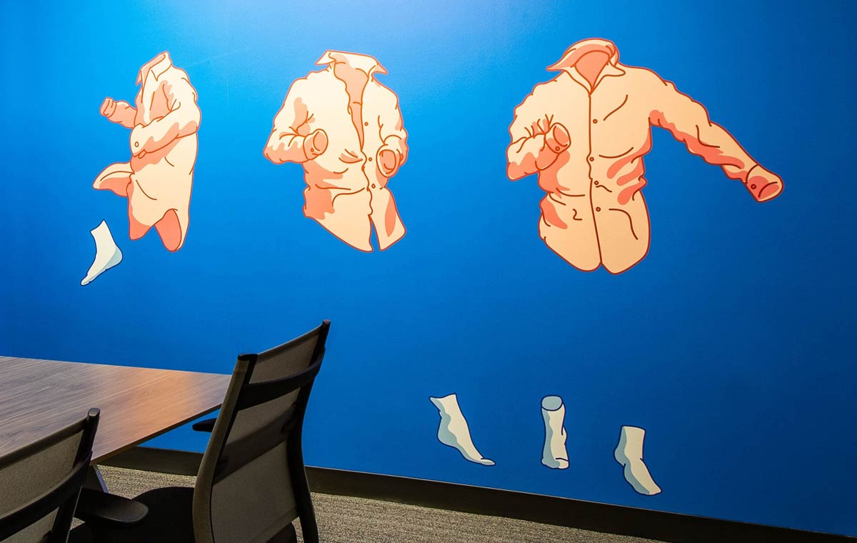 A bright blue custom graphic wall highlighting Environmental Branding vs. Experiential Design in Corporate Interiors