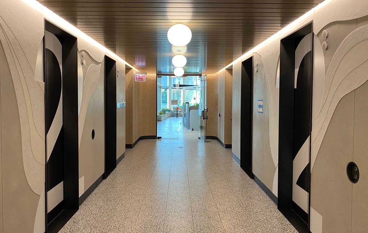 A corporate corridor with custom design and fabrication elements along the walls and doors
