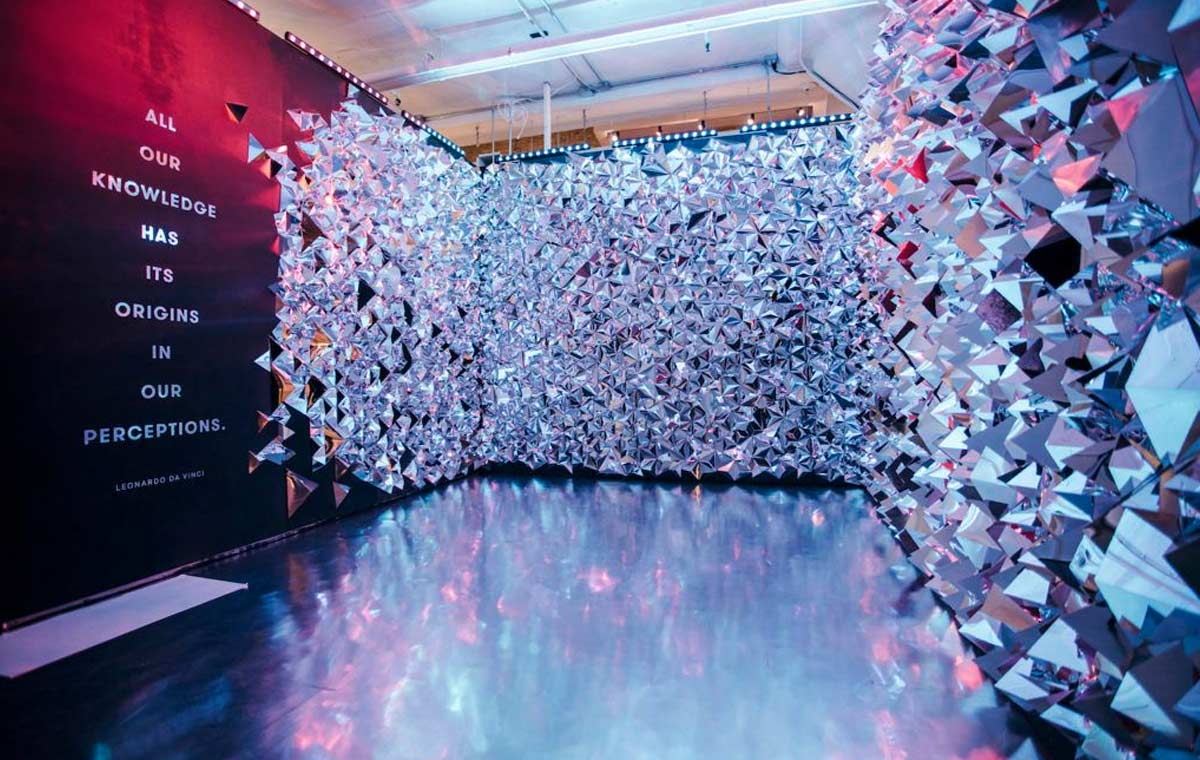 An exhibition room designed with multifaceted, mirrored crystals all over the walls creating a bejeweled effect