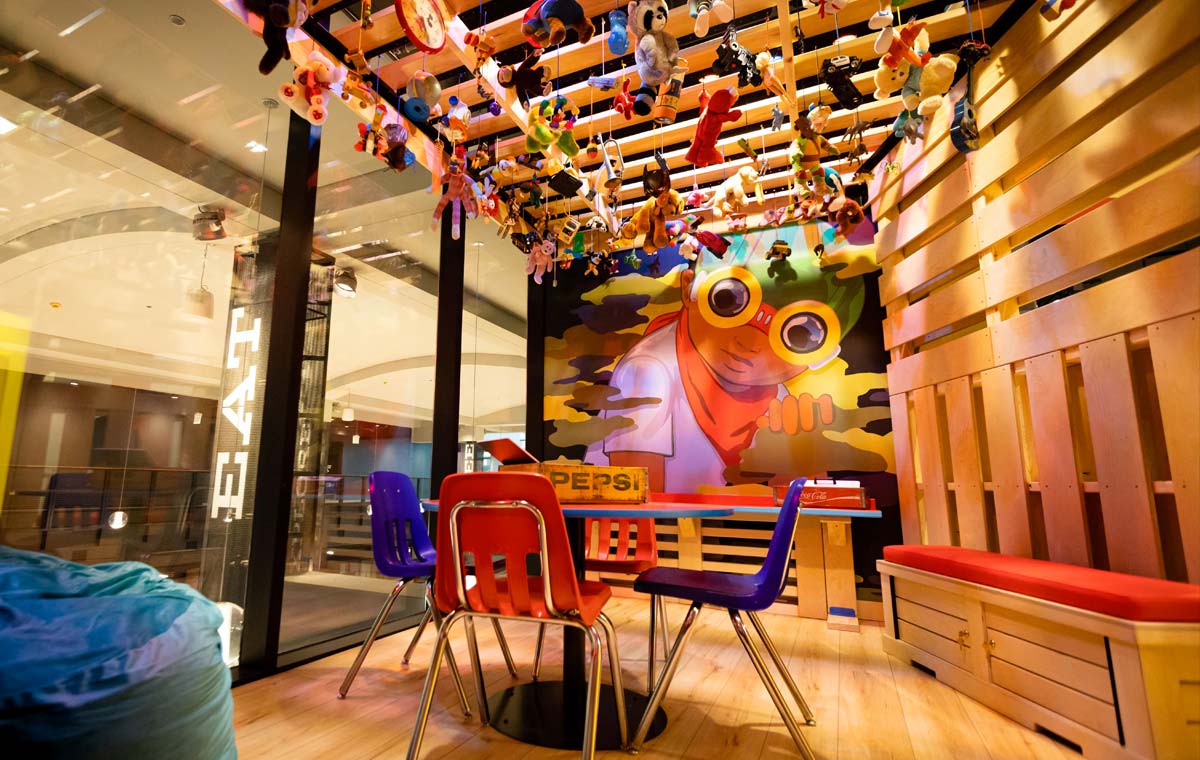 A colorful room with wood slats, children's chairs and toys hanging from the ceiling at Chicago Children's Museum