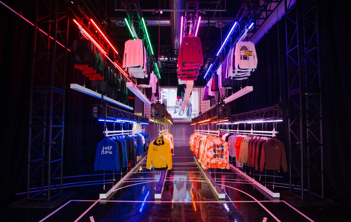 A dark neon lit is punctuated by brightly colored shirts over a basketball court floor at Nike's Jordan store