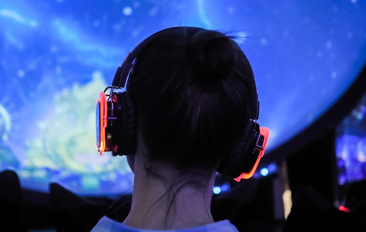 Child with headphones looking at an immersive art exhibit