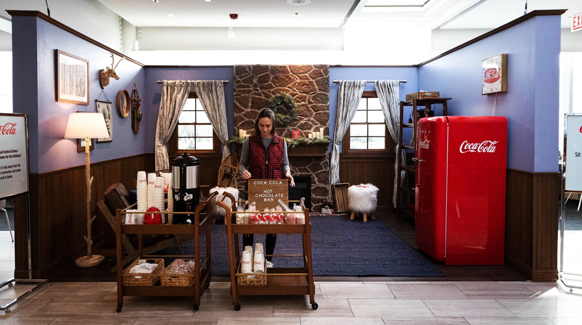 A woman enjoys an experiential marketing pop up from Coca-Cola in the Chicago O'Hare Airport